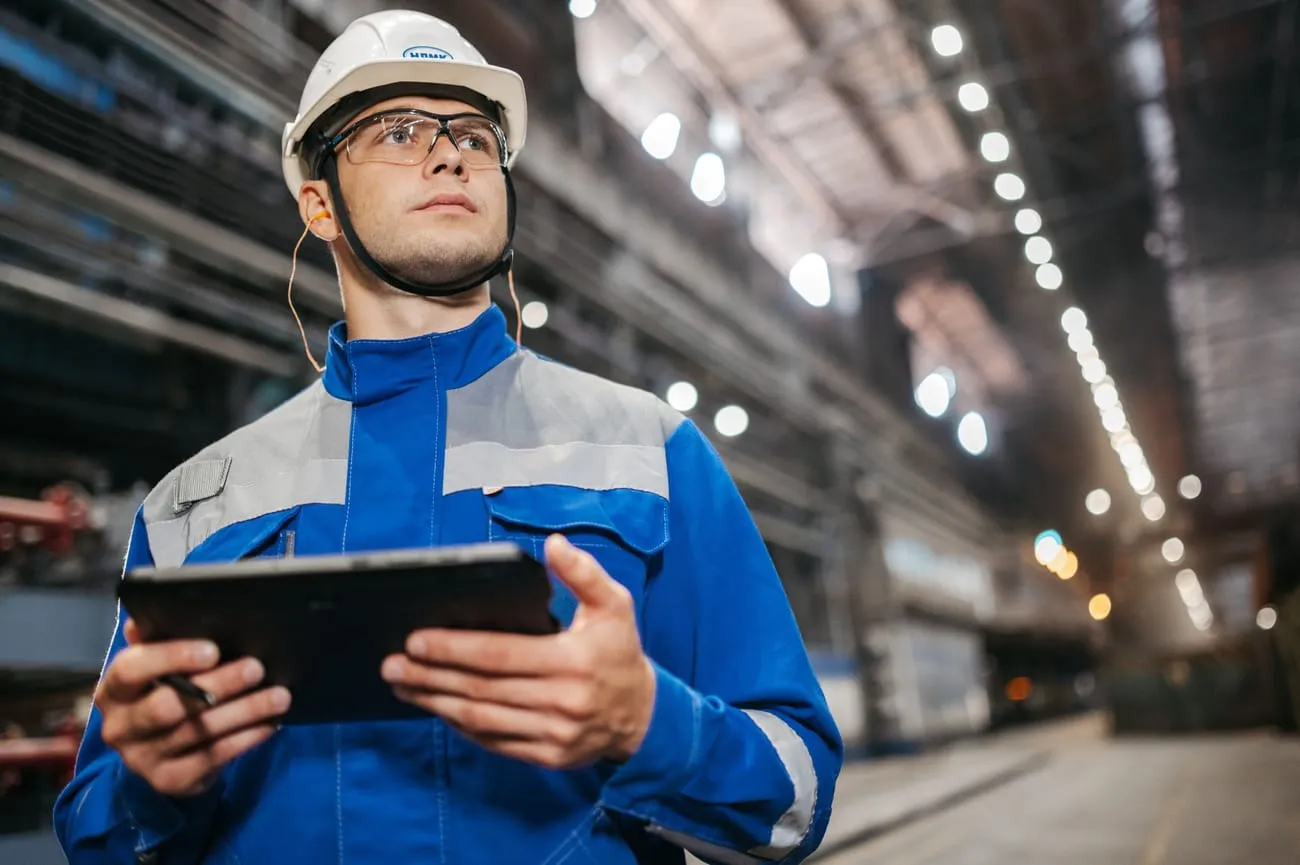 A plant worker reviewing a job order on a tablet.