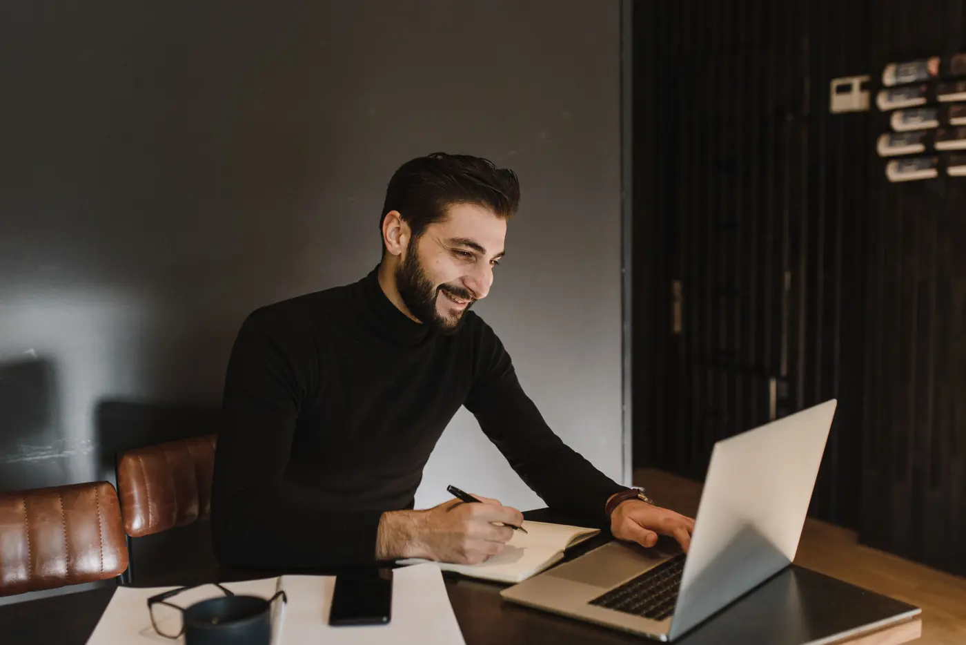 A recruiter smiling while reviewing candidates on a laptop