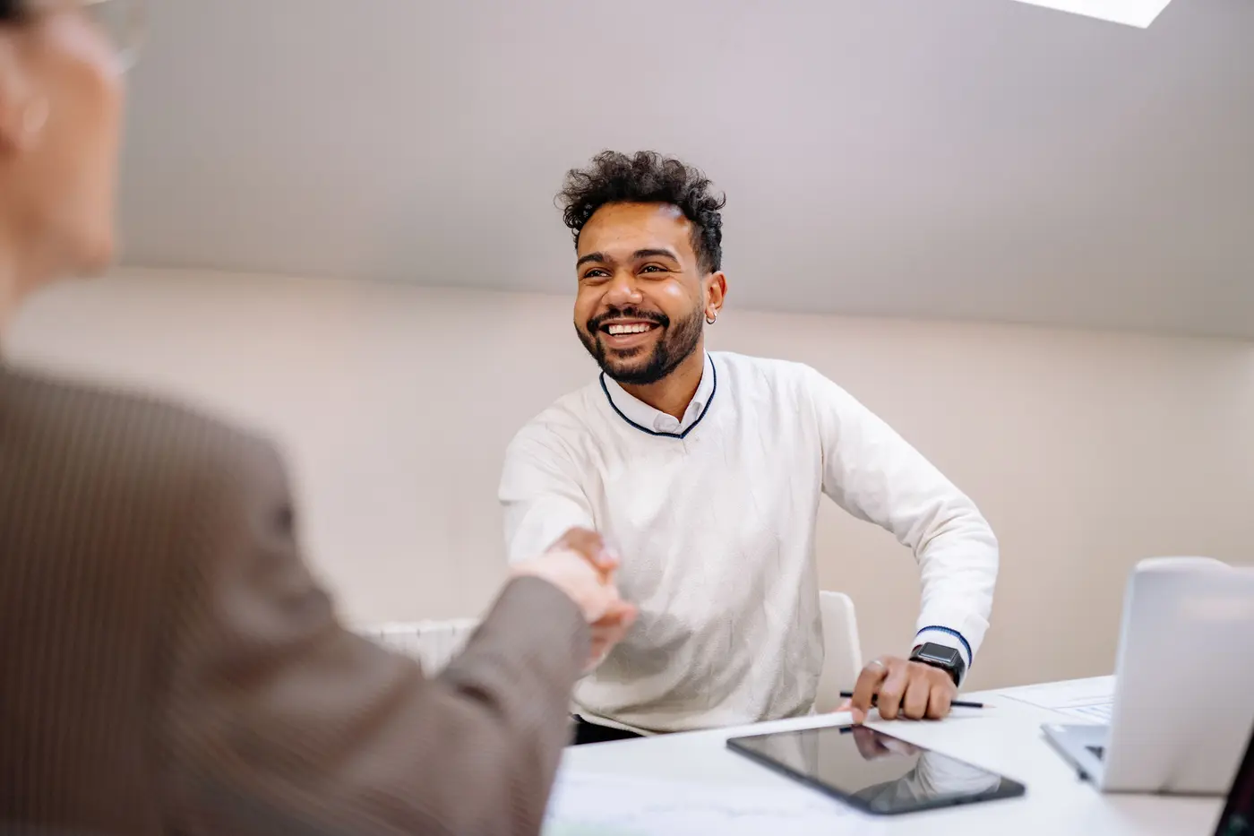 A staffing agency sales rep shaking hands with a client after a field visit